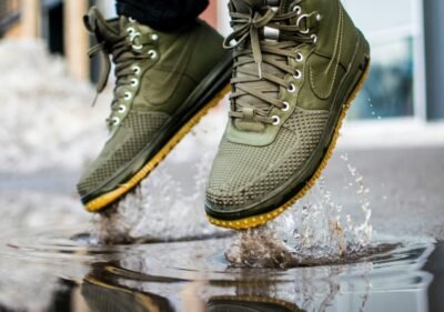 person wearing green Nike sneakers jumping on water